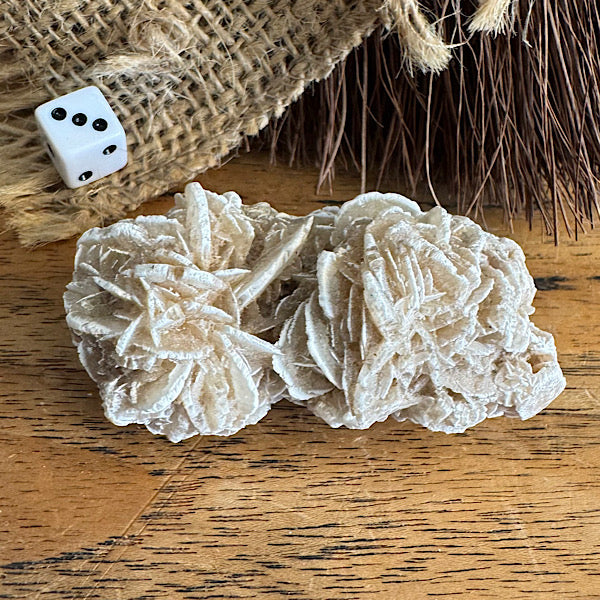 ruwe woestijnroos op een houten tafel met dobbelsteentje