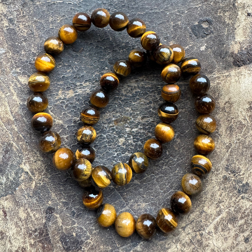tijgeroog Goud Armband 8mm Kralen gedragen op de pols – warme gouden edelstenen armband met kattenoog-effect