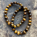 tijgeroog Goud Armband 8mm Kralen gedragen op de pols – warme gouden edelstenen armband met kattenoog-effect