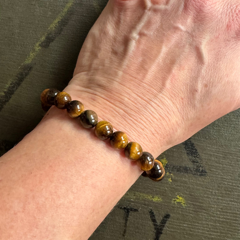 Vrouw draagt Tijgeroog Goud armband met 8mm kralen – krachtige gouden glans