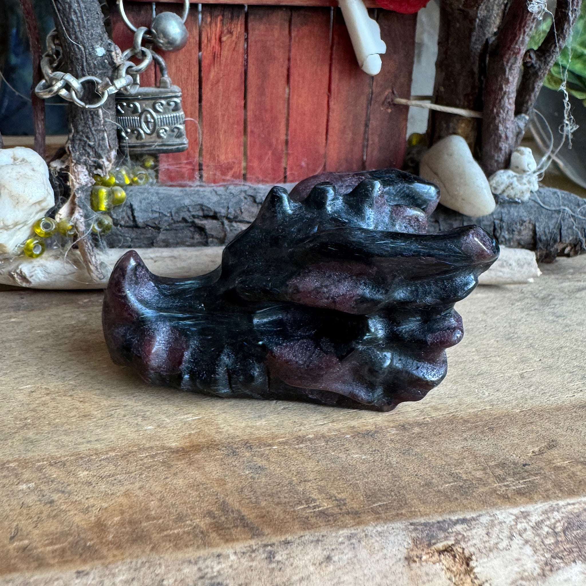 een zwart paarse drakenschedel van granaat in biotiet op een tafel