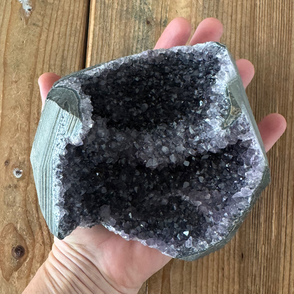 in de hand een amethist geode uit uruguay