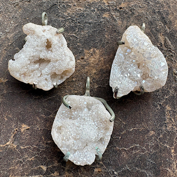 bergkristal ruw hangertje ketting sieraad liggend op een leder ondergrond