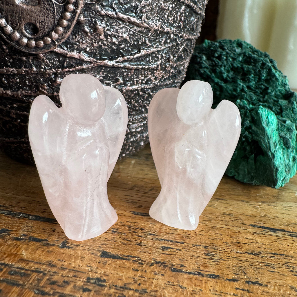 twee roze rozekwarts engeltjes gepolijst klein 4 cm hoog naar elkaar toe gezet op een plank