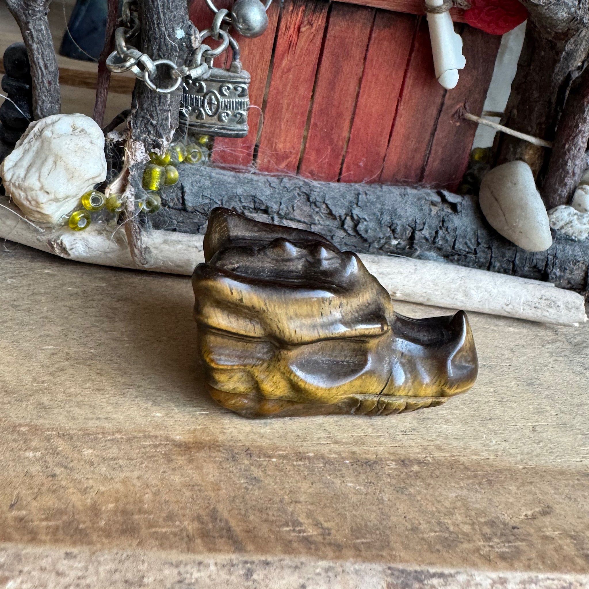 zijkant van een klein drakenschedel van edelsteen tijgeroog